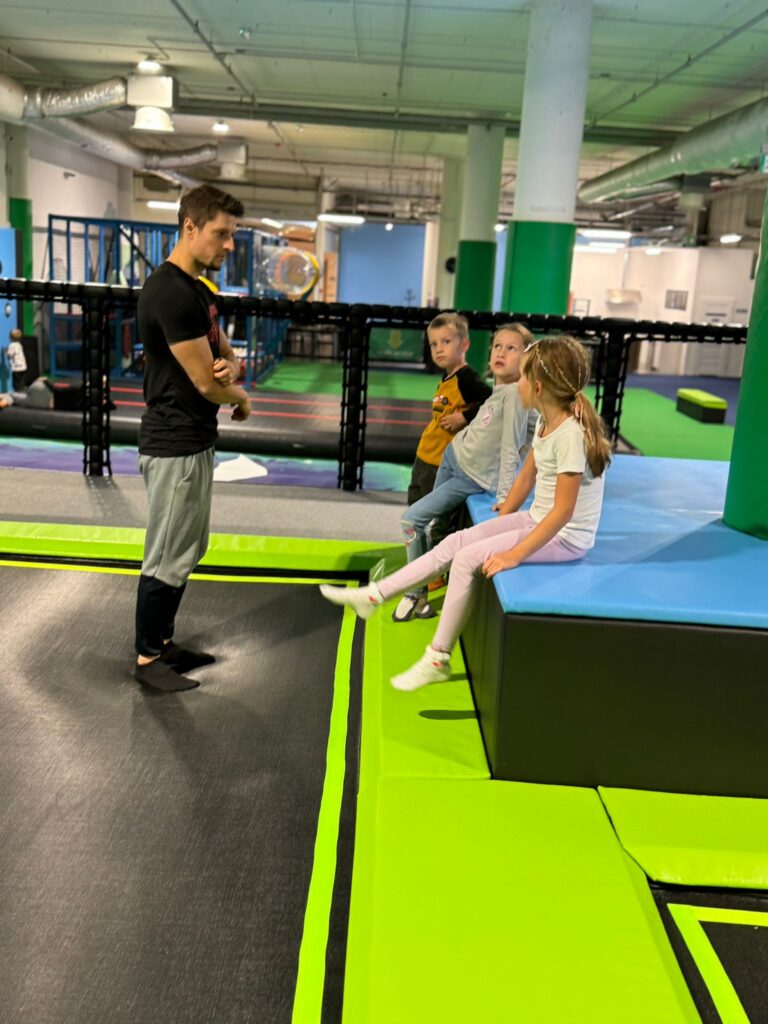 Dzieci z trenerem na zajęciach sportowych w Krakowie